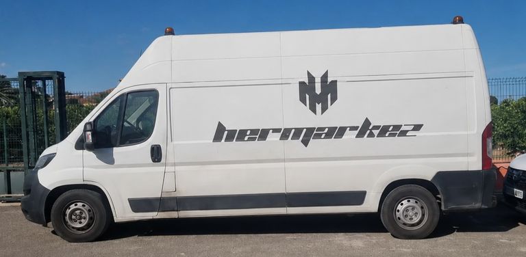 Furgoneta blanca de Transportes Hermarkez rotulada con el logotipo de la empresa, lista para una mudanza en Vera, Almería